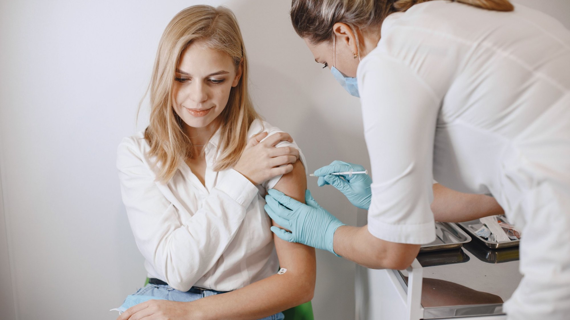 Nurse giving a patient an injection in the upper arm